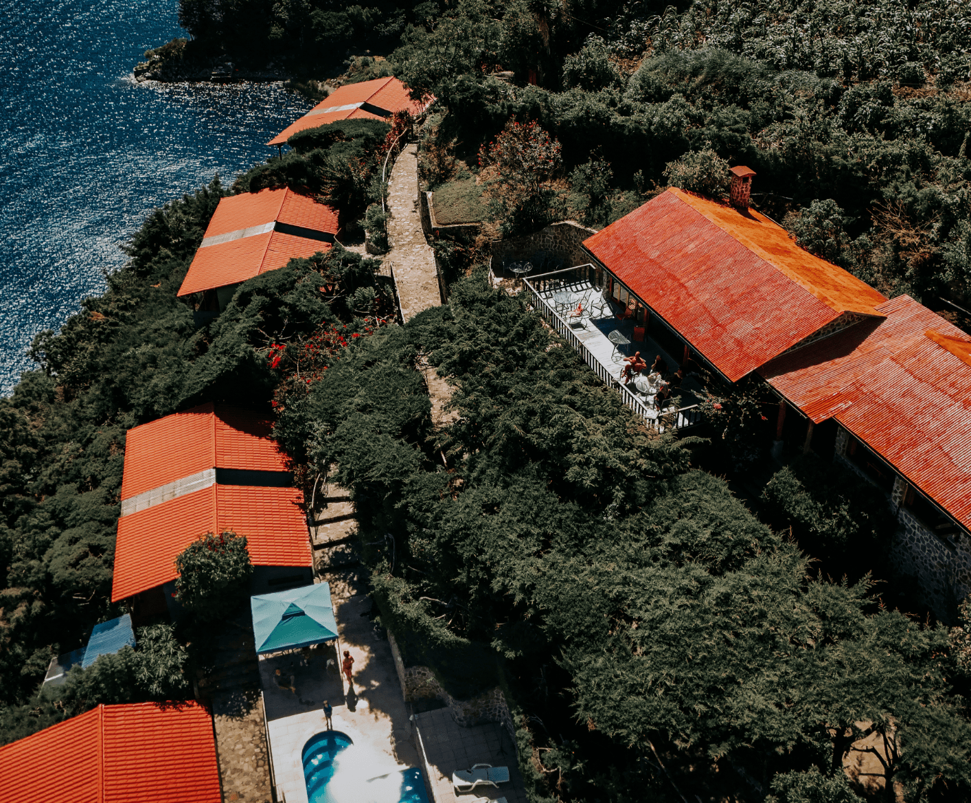 Aerial overhead view of Loma de Atitlan campus with bungalows, pool, and lake