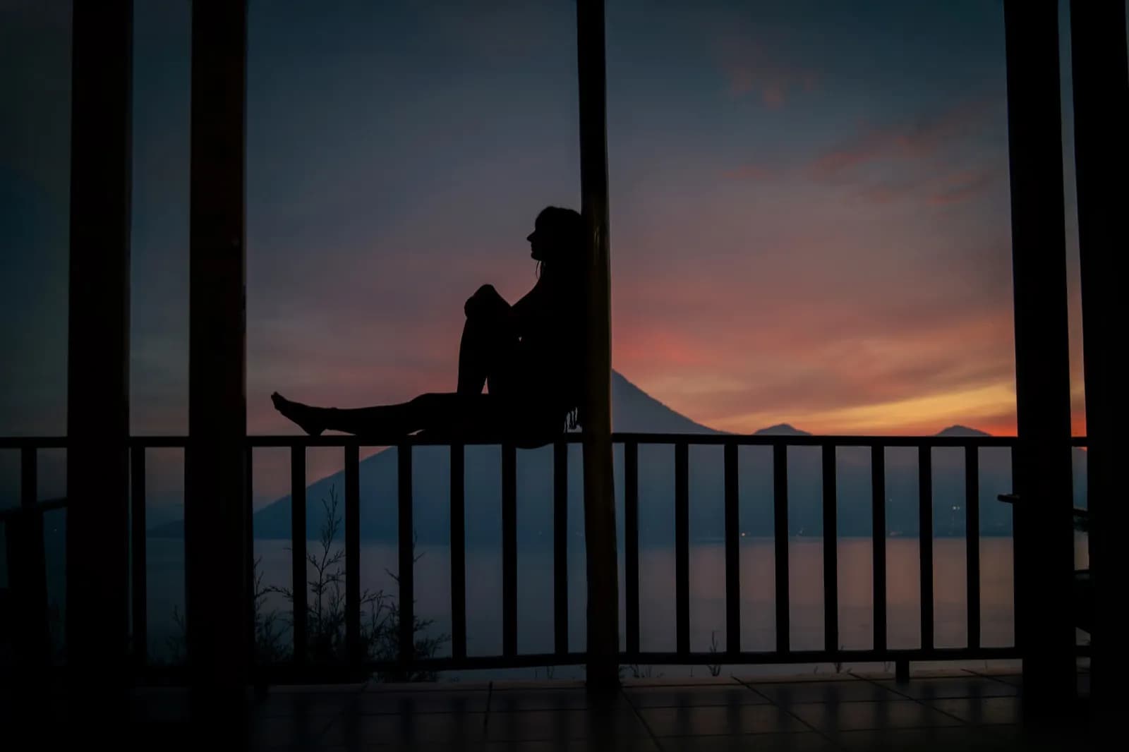 Silhouette at sunset over Lake Atitlan volcanoes